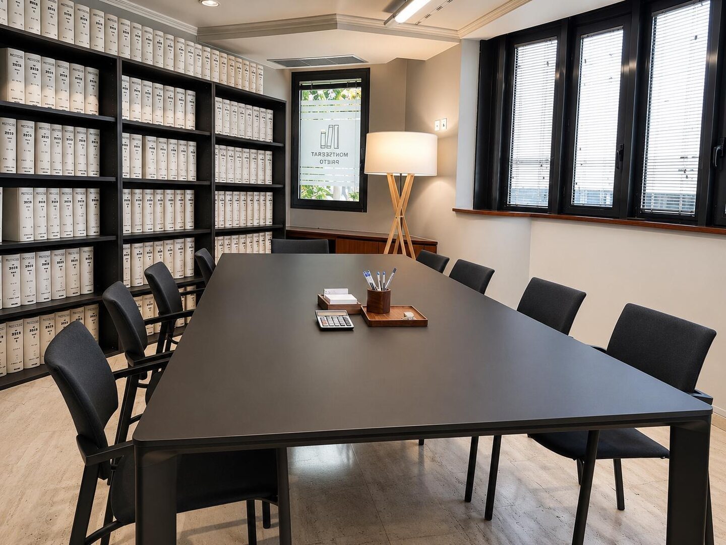 Sala de firmas con mesa larga junto a las estanterías de protocolos